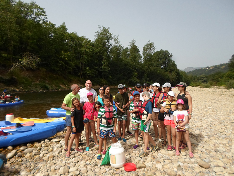 Grupo de niños y adultos divirtiéndose en el Rio Sella